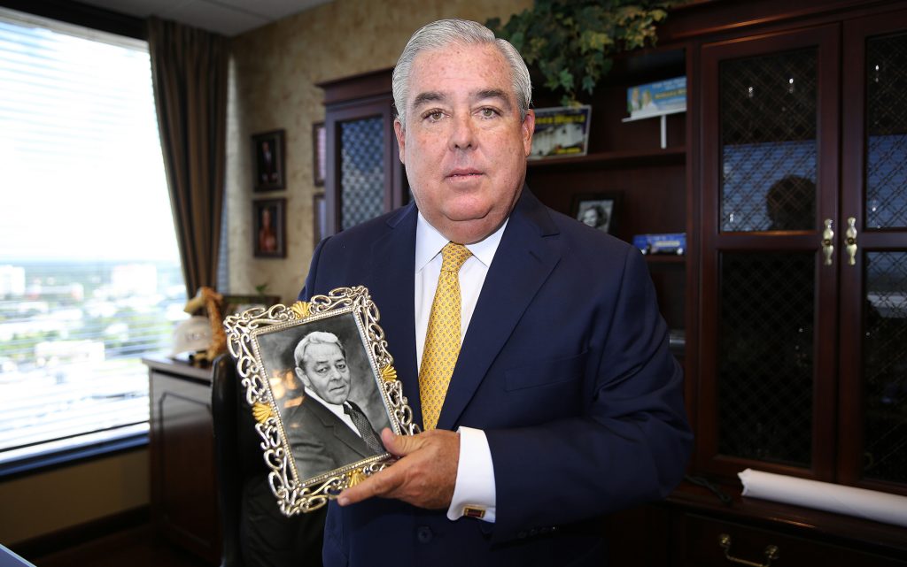 Florida attorney John Morgan holds a photo is his late father Ramon, who passed away from cancer. This image of him was taken in his office at the Morgan and Morgan law firm in Orlando, Florida on Tuesday, September 2, 2014. (AP Photo/Alex Menendez)