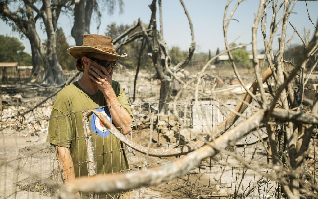 James McCauley weeps while looking over the burned out remains of his prized marijuana plant and what's left of his residence in the town of Lower Lake, Calif. on August 15, 2016. McCauley traversed a creek by boat for a half mile to see the property. (AP Photo/Josh Edelson)