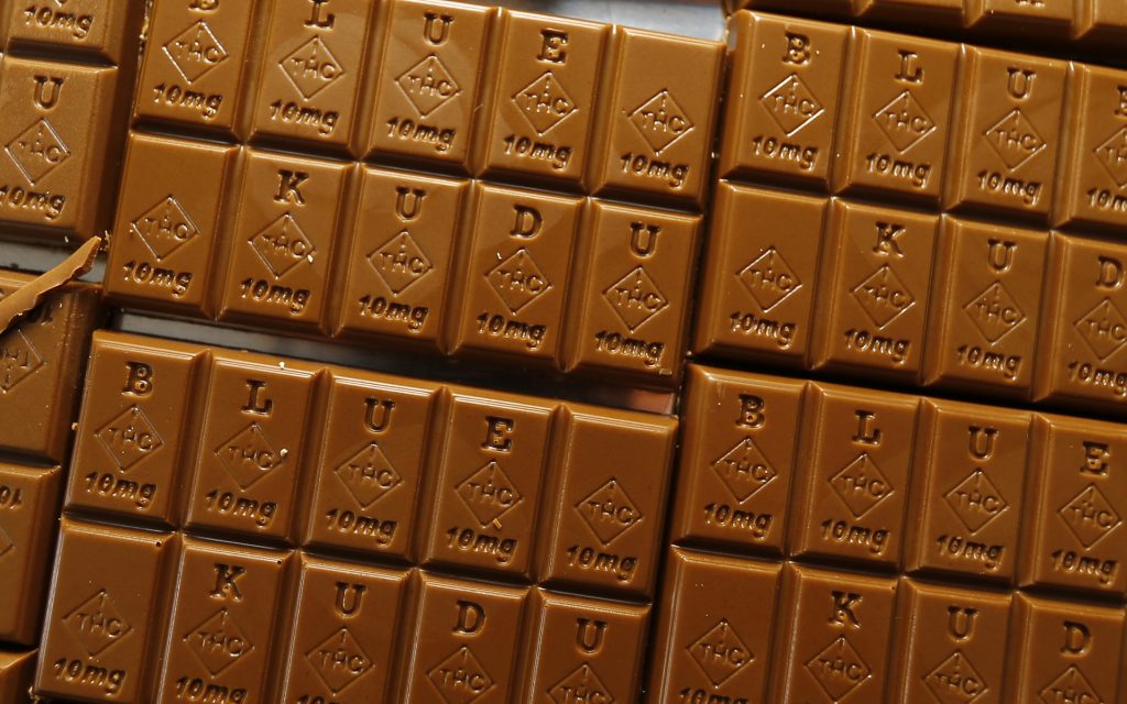 Chocolate bars marked with Colorado's new diamond-shaped stamp noting that the product contains cannabis. State officials require the stamp to be put directly on edibles after complaints that the treats look too much like their non-intoxicating counterparts. (AP Photo/David Zalubowski)