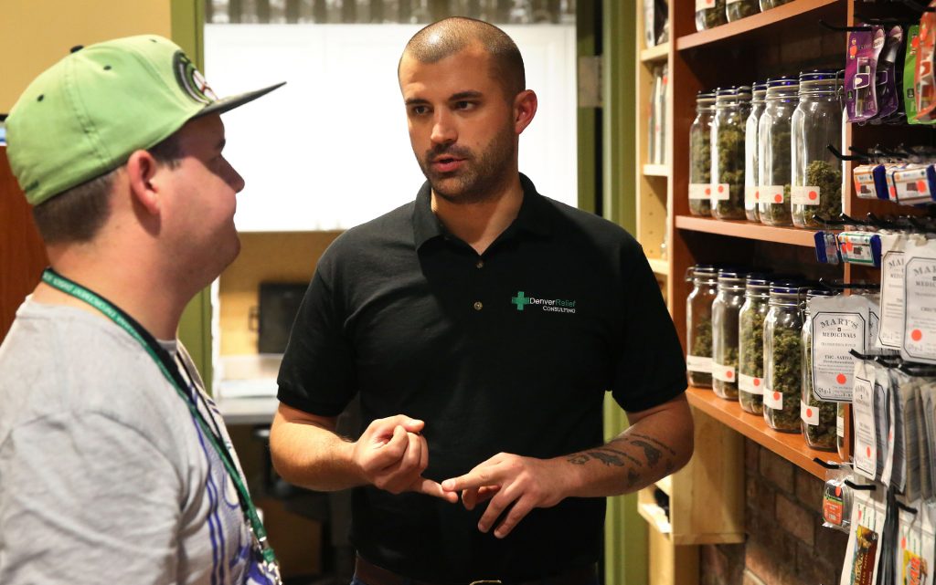 Denver Relief co-owner Kayvan Khalatbari, right, talks with his employee Jeff Botkin at his shop in Denver. (AP Photo/Brennan Linsley, File)