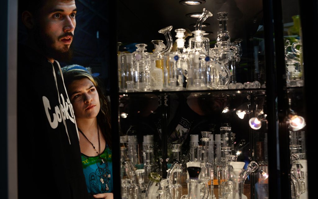 Zach Trent, left, and Jennifer Sic looking over glass products on display at The Mighty Quinn booth.