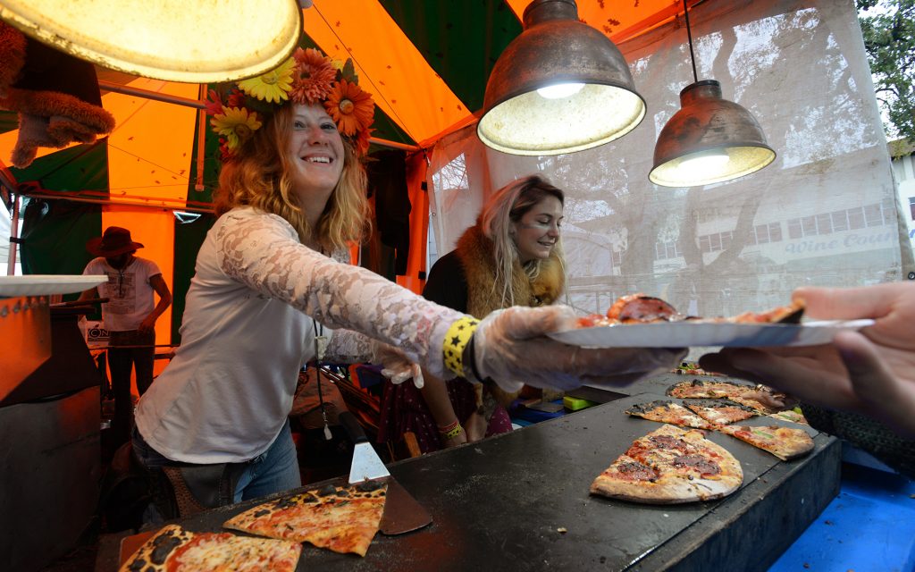 Michelle Smith, left, handing out slices of pizza with Stephanie Tholl at the Home Slice Pizza stand.